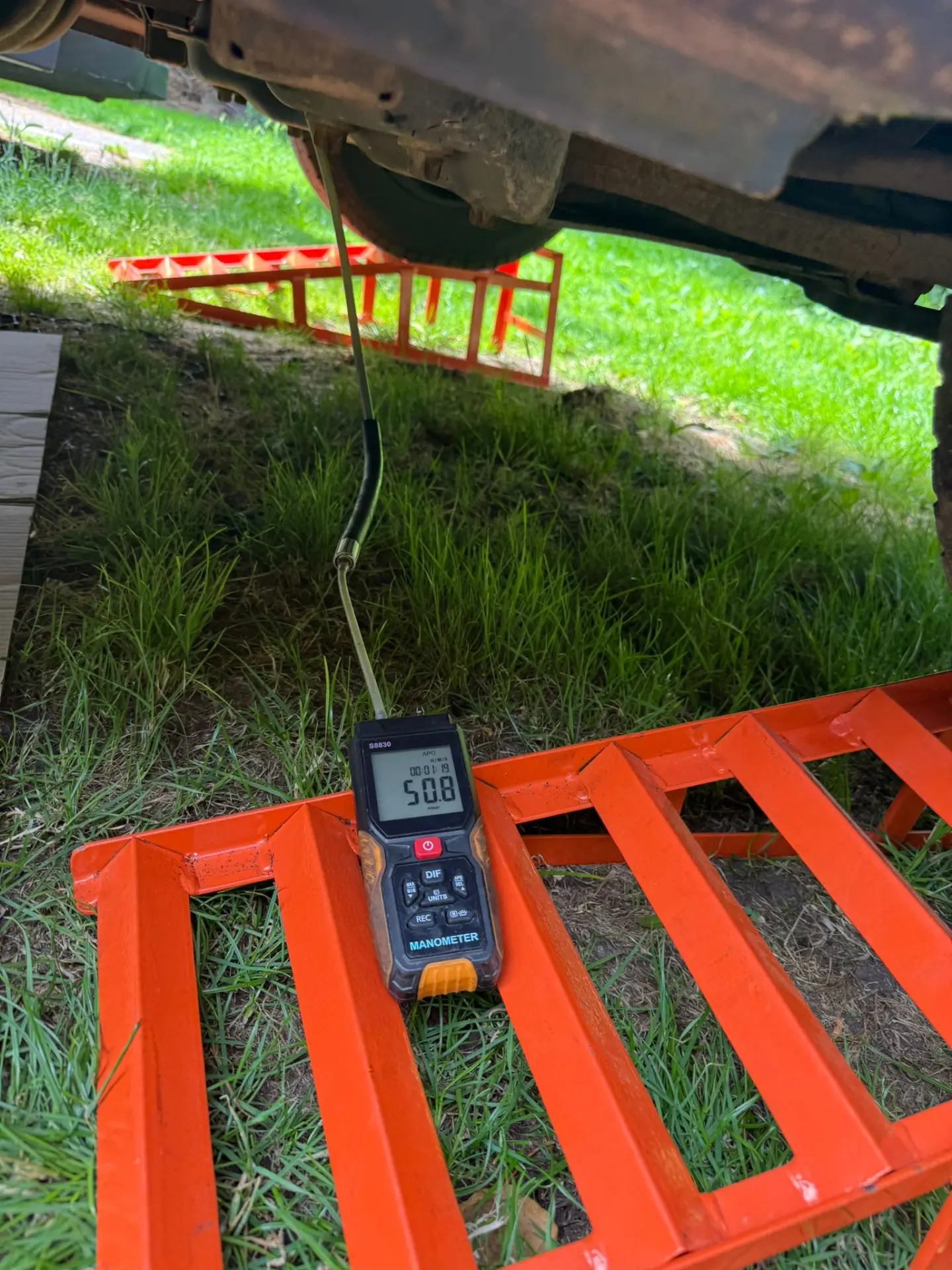 Technician performing DPF pressure diagnostics on a Citroën Relay using a digital manometer, showing an initial reading of 50.8 mbar before DPF cleaning.