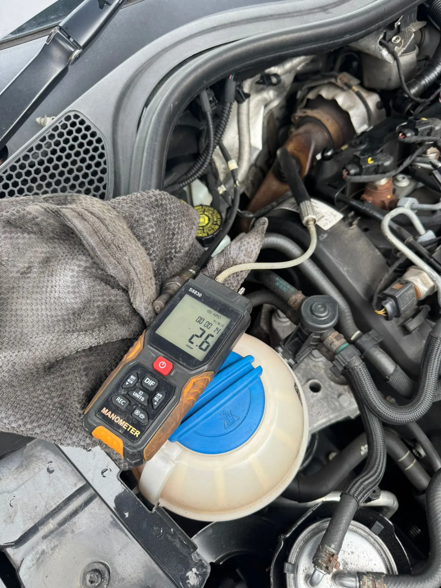Digital manometer displaying 2.6 mbar DPF pressure before cleaning on an Audi A1 engine during a GMM1 diagnostic inspection.