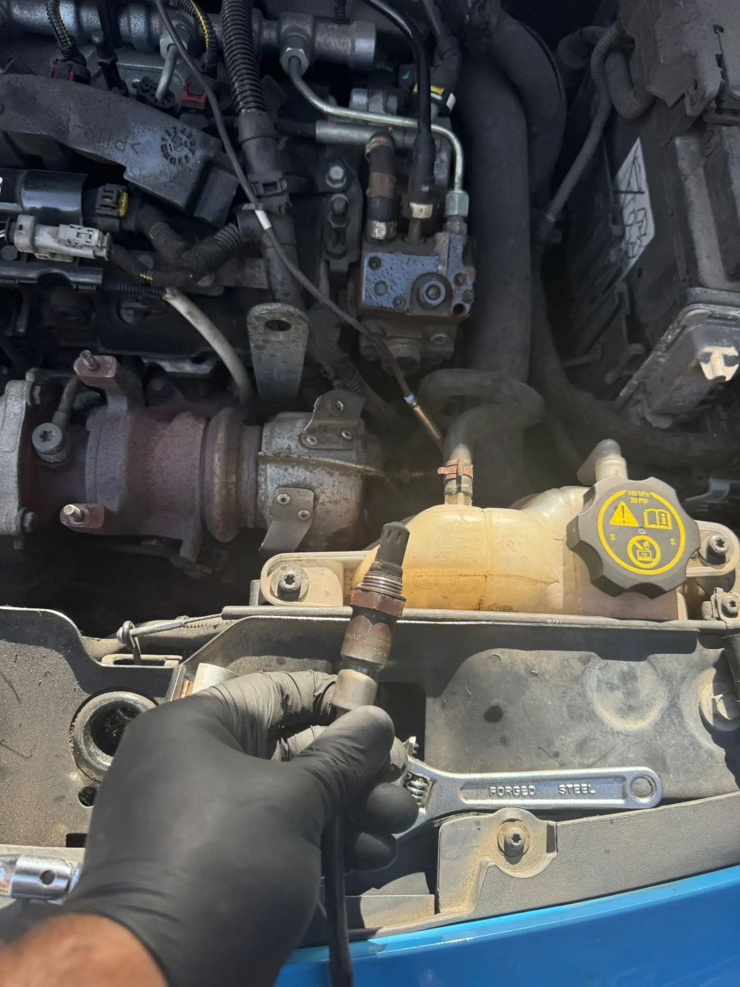 Technician holding the DPF pressure sensor during a Vauxhall Astra Van DPF cleaning service before testing exhaust back pressure.