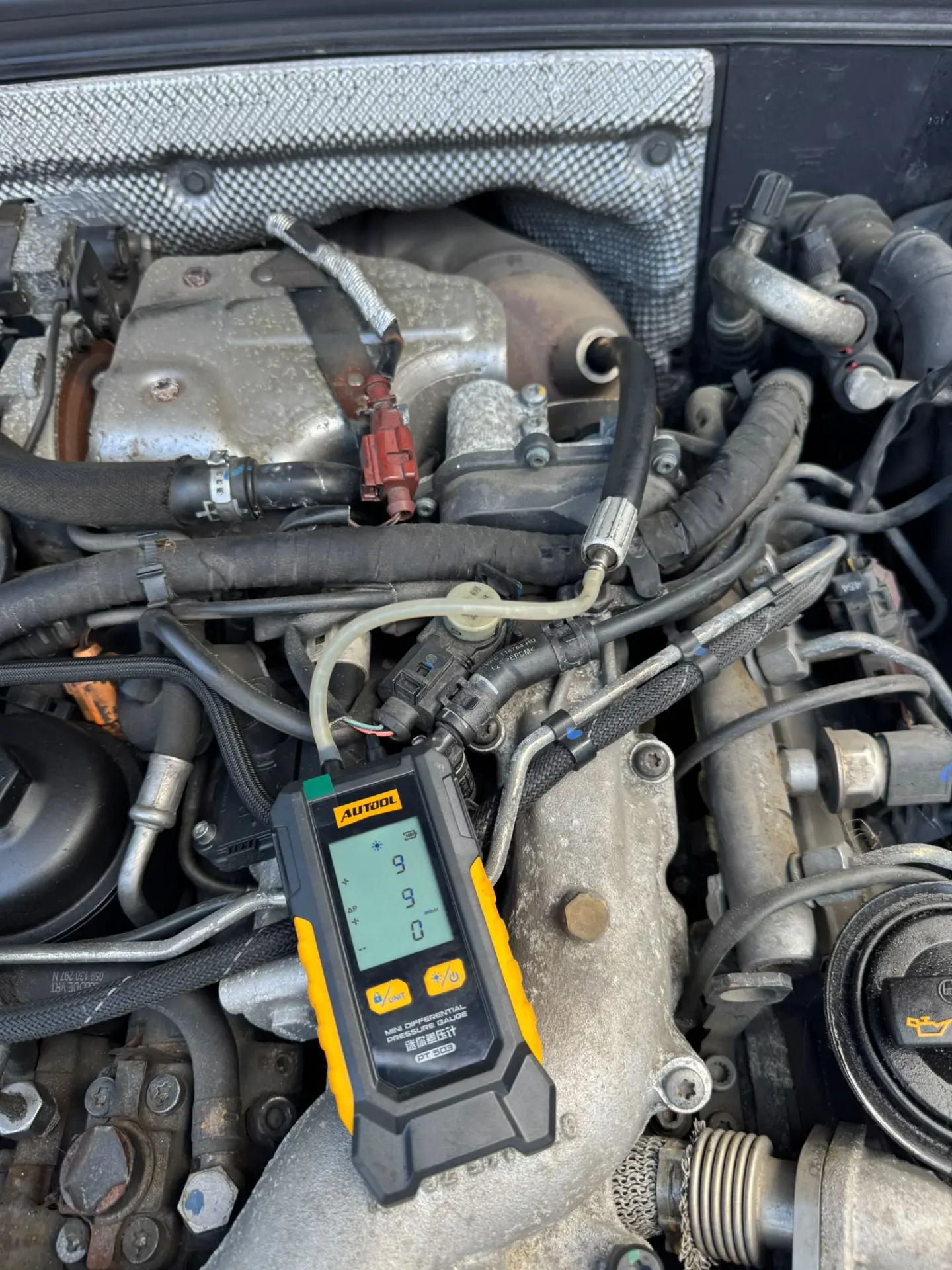 Professional DPF differential pressure testing in progress using an AUTool diagnostic gauge connected to the engine bay as part of a mobile diesel particulate filter cleaning service.