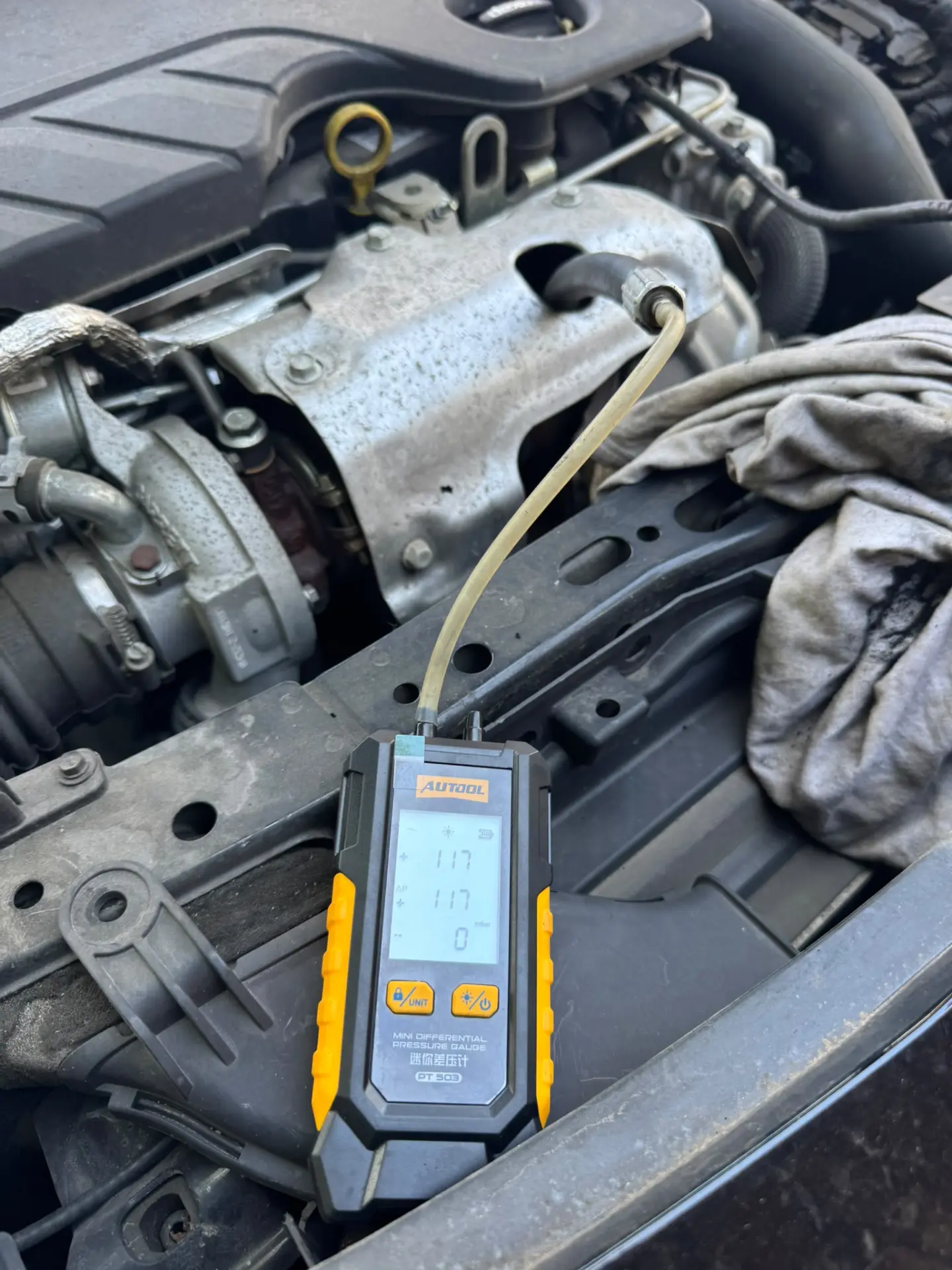 Technician performing an initial DPF pressure test on a Vauxhall Astra in West Ealing, London, showing 117 mbar before professional DPF cleaning.