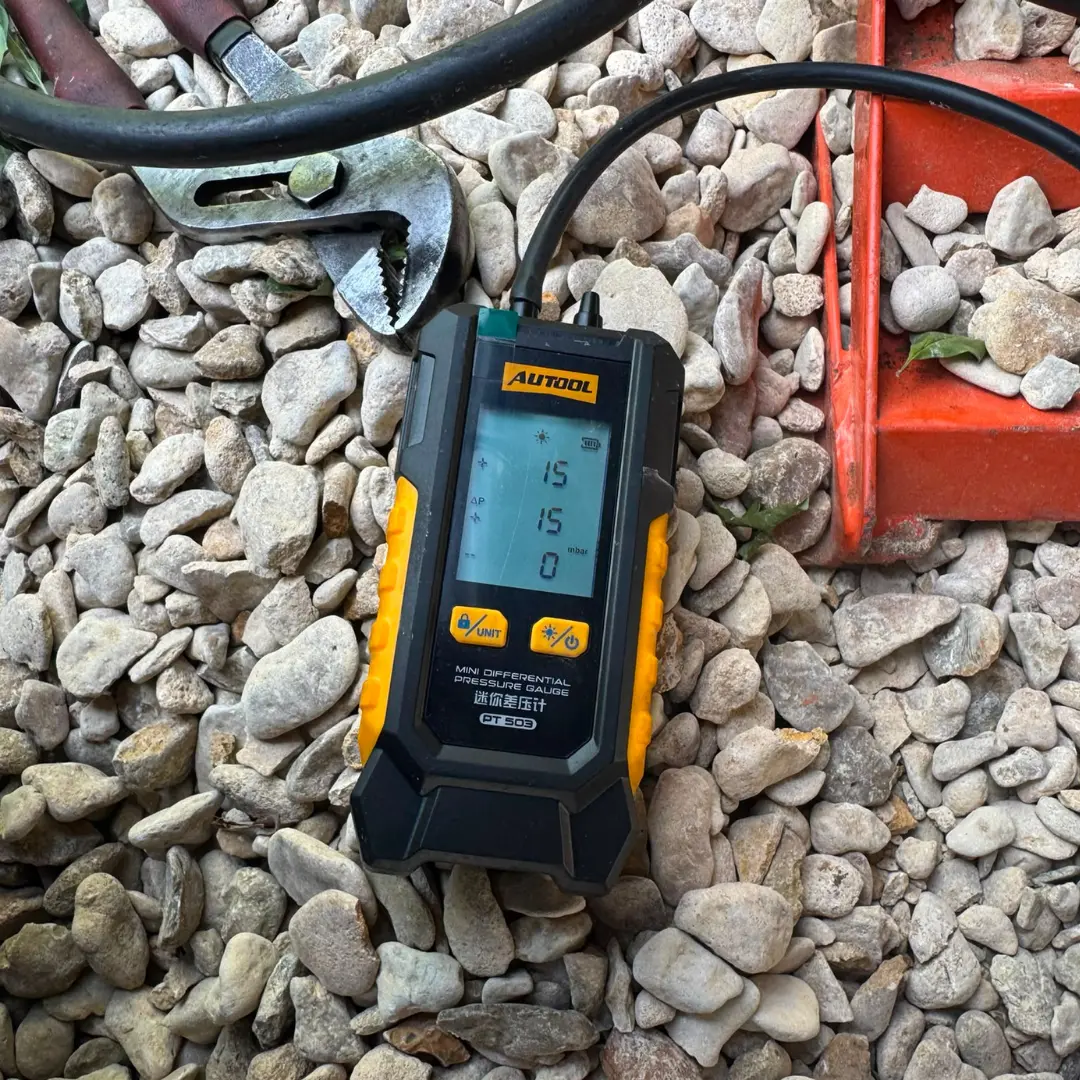 Digital differential pressure gauge showing a post-cleaning DPF pressure reading of 15 mbar after successful Diesel Particulate Filter cleaning.