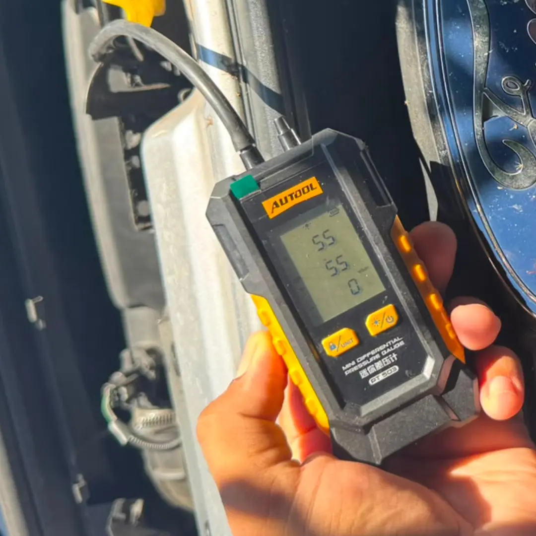 Ford Custom DPF pressure test before cleaning showing a 55 mbar reading on a handheld diagnostic pressure gauge.